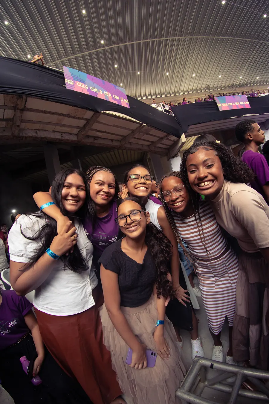 Grupo de adolescentes abraçados e sorrindo durante o congresso