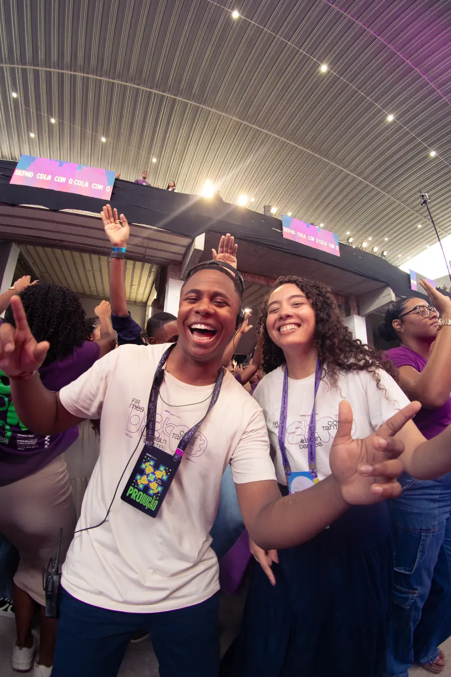 Dupla da equipe de produção comemorando no meio do público