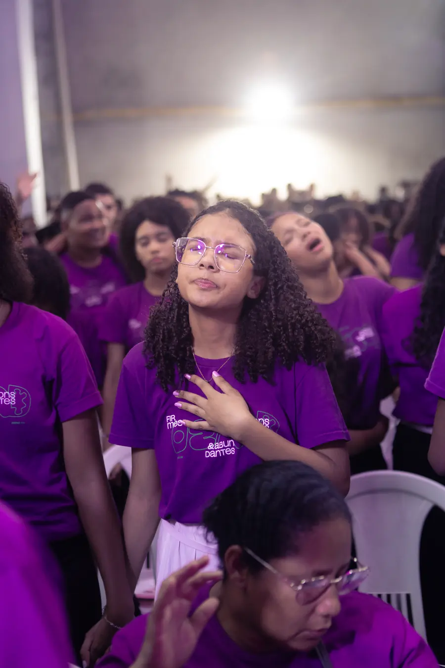 Adolescente em momento de oração com a mão sobre o peito